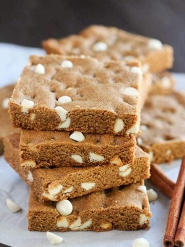 Stack of gingerbread cookie bars filled with white chocolate chips.