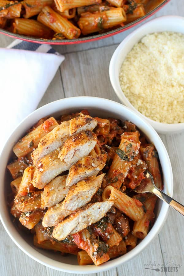 Pasta in a bowl topped with chicken.