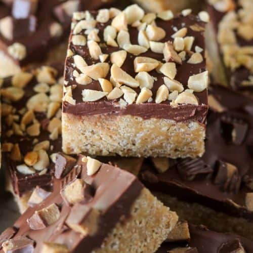 Peanut butter rice krispies treats topped with chocolate and peanuts.