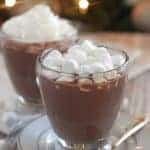 Hot chocolate in a glass topped with marshmallows.