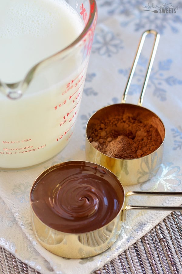 Nutella and cocoa in gold measuring cups.