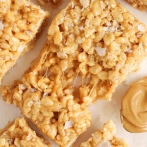 Closeup of a gooey peanut butter rice krispies treat topped with flaky sea salt.