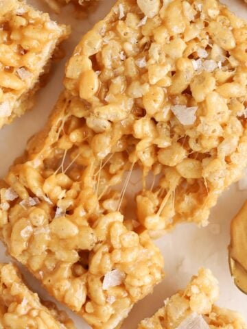 Closeup of a gooey peanut butter rice krispies treat topped with flaky sea salt.