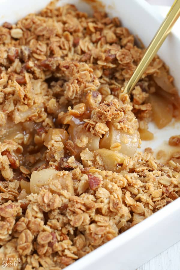 Healthy Apple crisp in a white casserole dish with a gold spoon