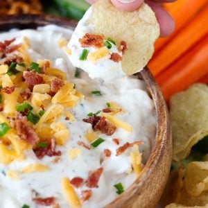 Chips and dip topped with bacon, cheese, and chives.