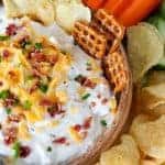 Chips and dip topped with bacon, cheese, and chives.