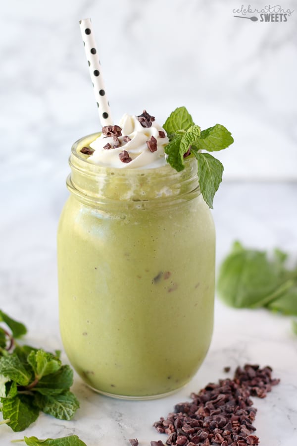 Green smoothie in a jar topped with whipped cream.