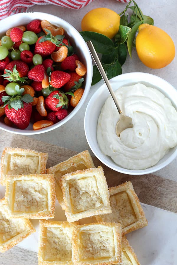 Tart shells, whipped cream, and a bowl of fruit.