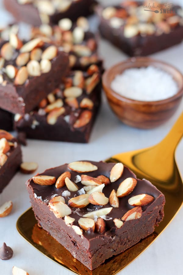 Brownies topped with frosting and almonds.