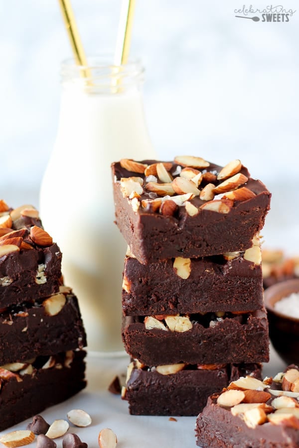 Stack of brownies topped with frosting and almonds.
