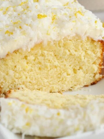 Lemon coconut cake topped with frosting and shredded coconut