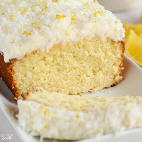Lemon coconut cake topped with frosting and shredded coconut