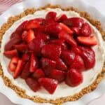 Strawberry cream cheese pie in a graham cracker crust in a white pie plate,