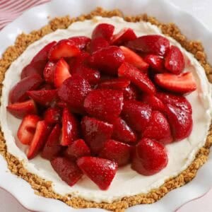 Strawberry cream cheese pie in a graham cracker crust in a white pie plate,
