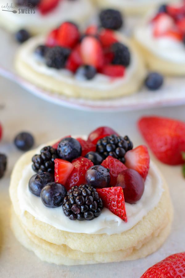 Sugar cookies topped with frosting and berries. 