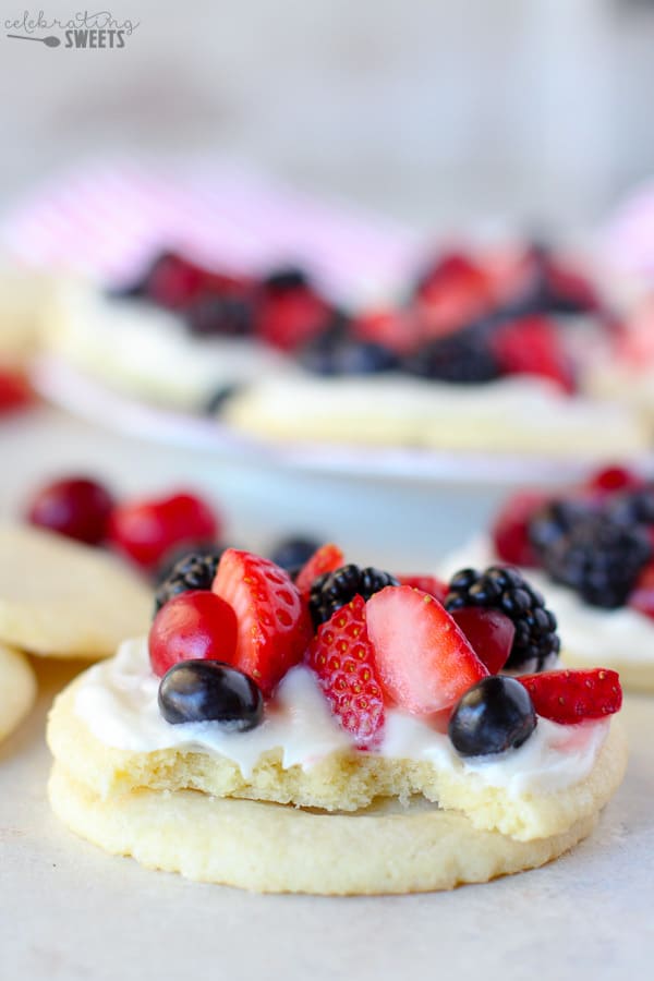 Sugar cookies topped with frosting and berries. 