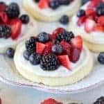Sugar cookies topped with frosting and berries.