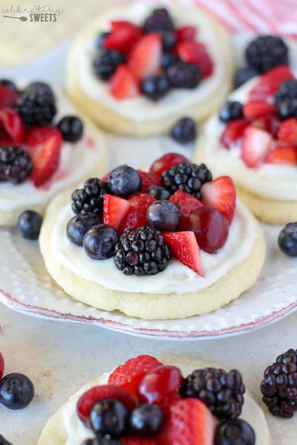 Sugar cookies topped with frosting and berries. 