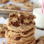 Stack of chocolate chip cookies with milk in the background.