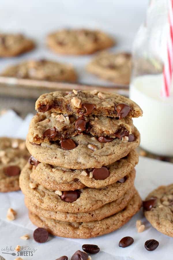 Stack of chocolate chip cookies with milk in the background. 