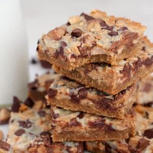 Stack of Peanut Butter Cup Magic Cookie Bars with Milk in the Background