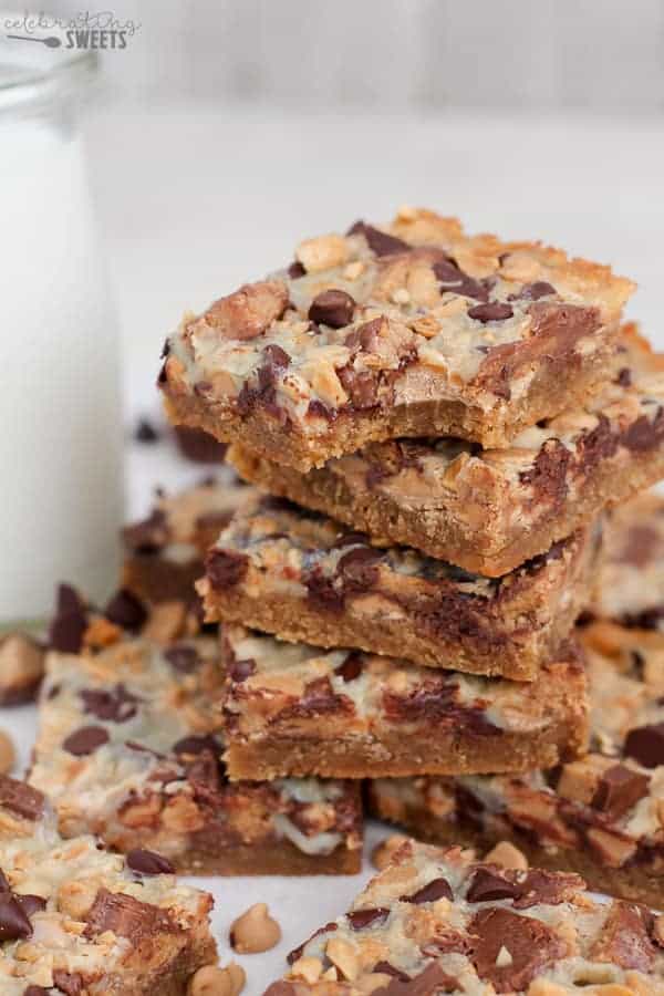 Stack of Peanut Butter Cup Magic Cookie Bars with Milk in the Background