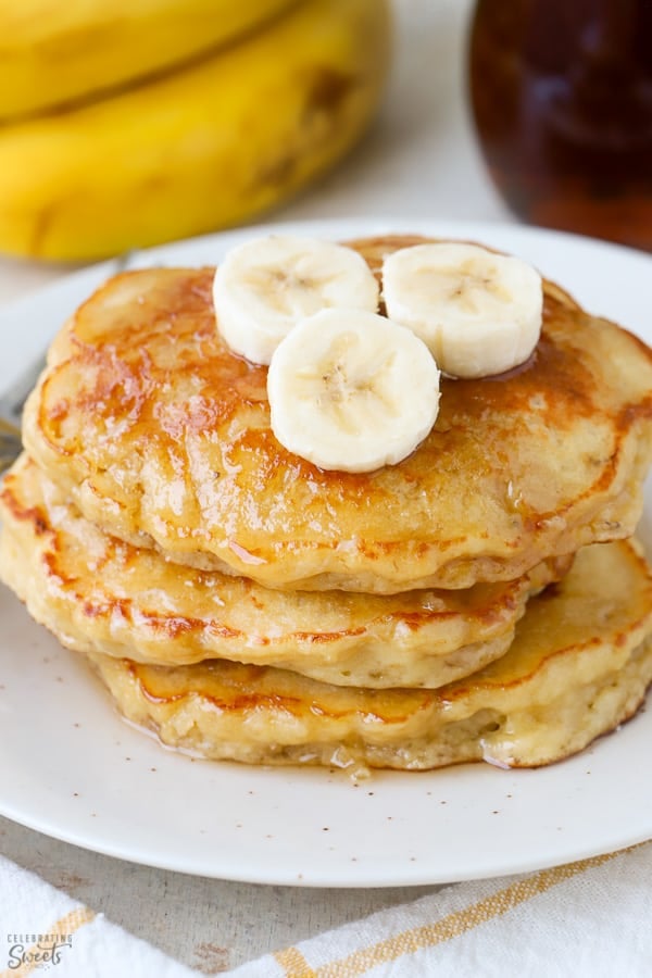 Stack of three banana pancakes on a white plate.
