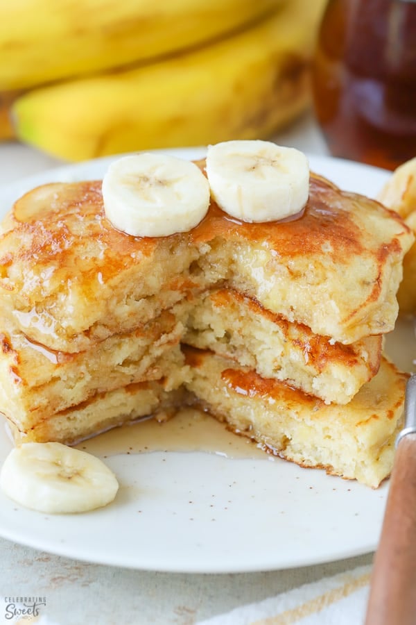 Stack of three banana pancakes on a white plate.