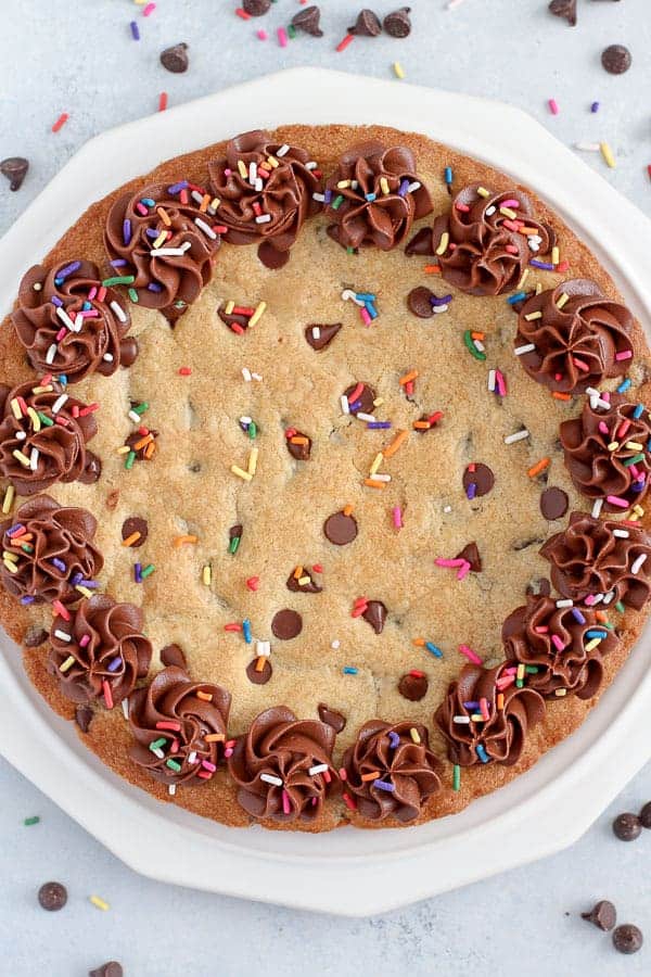 Giant chocolate chip cookie decorated with chocolate frosting and sprinkles. 
