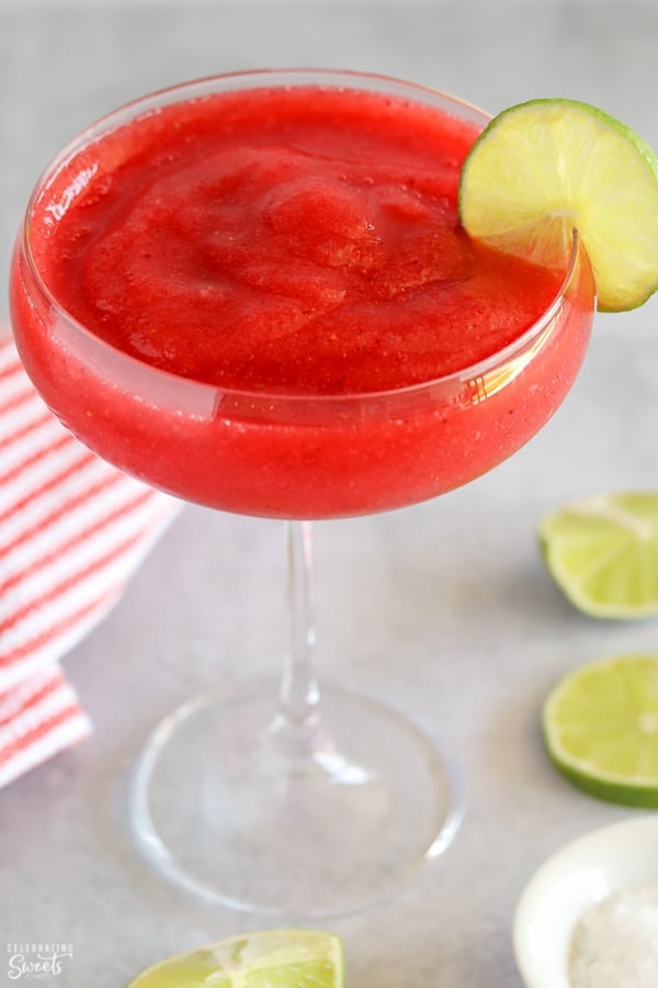 Frozen strawberry margarita garnished with lime.