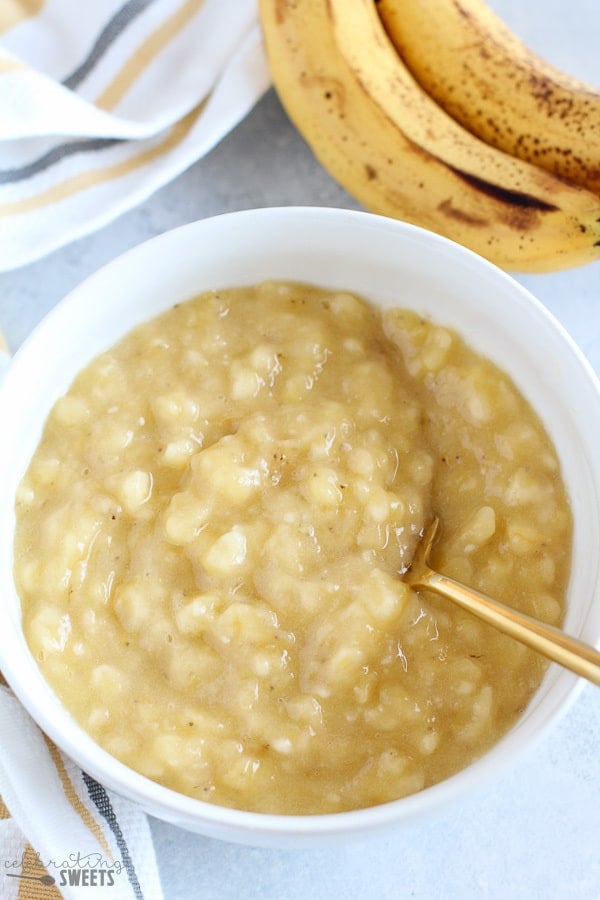 Mashed bananas in a white bowl.