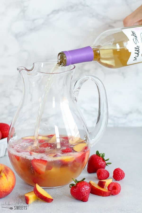 Wine poured into a pitcher for peach sangria.