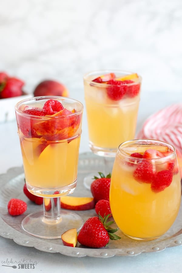 Three glasses of peach sangria on a tray.