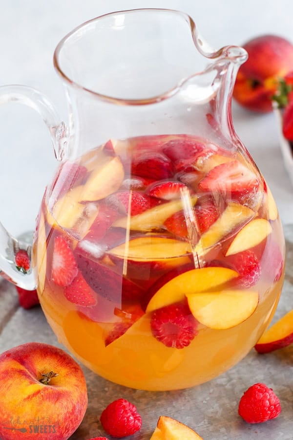 Peach Sangria in a glass pitcher.