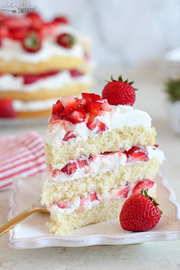 Three layer Strawberry Shortcake Cake on a white plate.