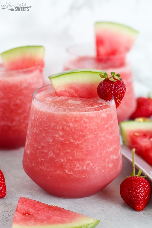 Pink wine slushie garnished with watermelon and strawberry.