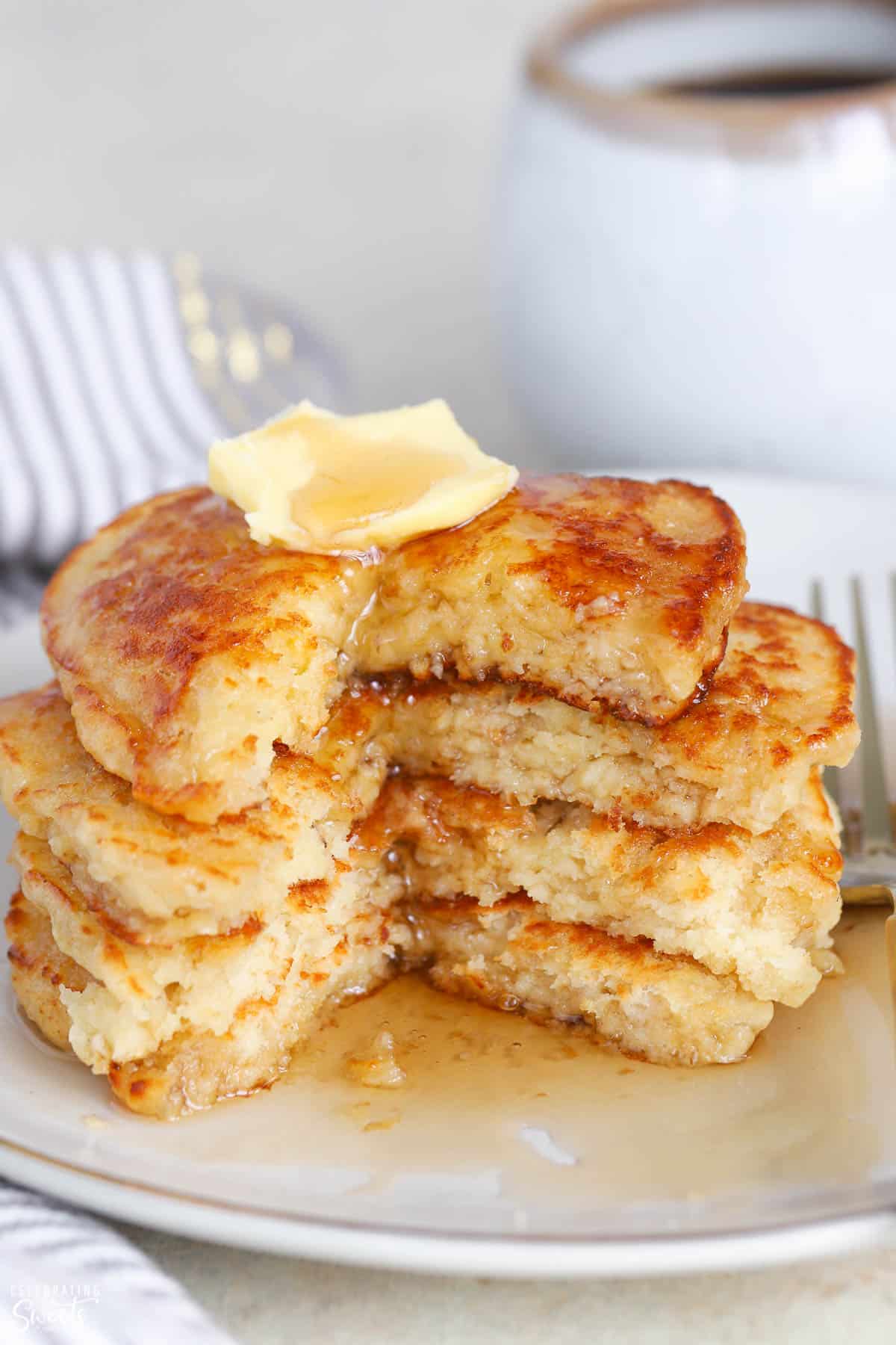 Stack of pancakes topped with butter and syrup.