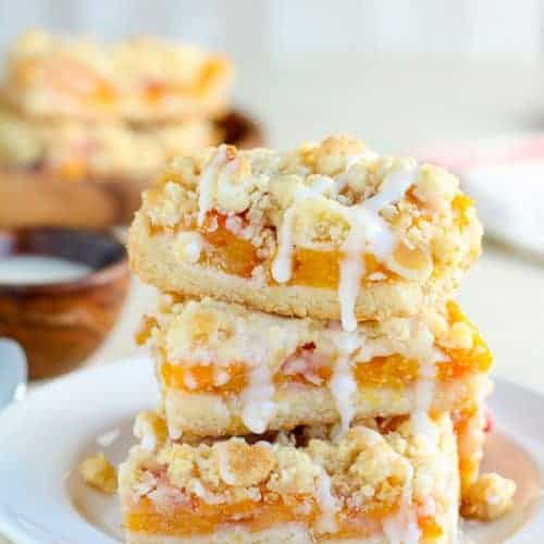 Stack of Peach Crumb Bars on a white plate.
