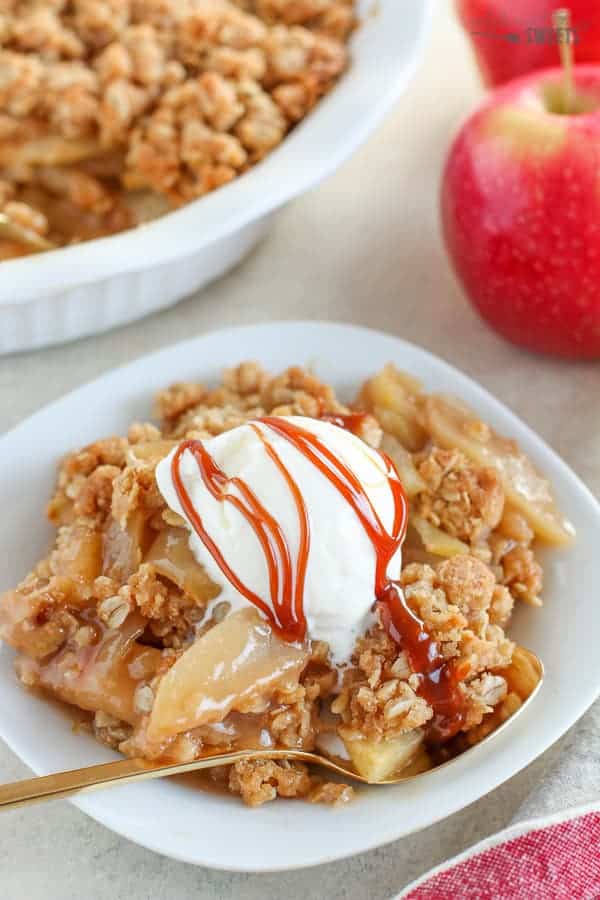 Apple crisp topped with ice cream and caramel sauce. 