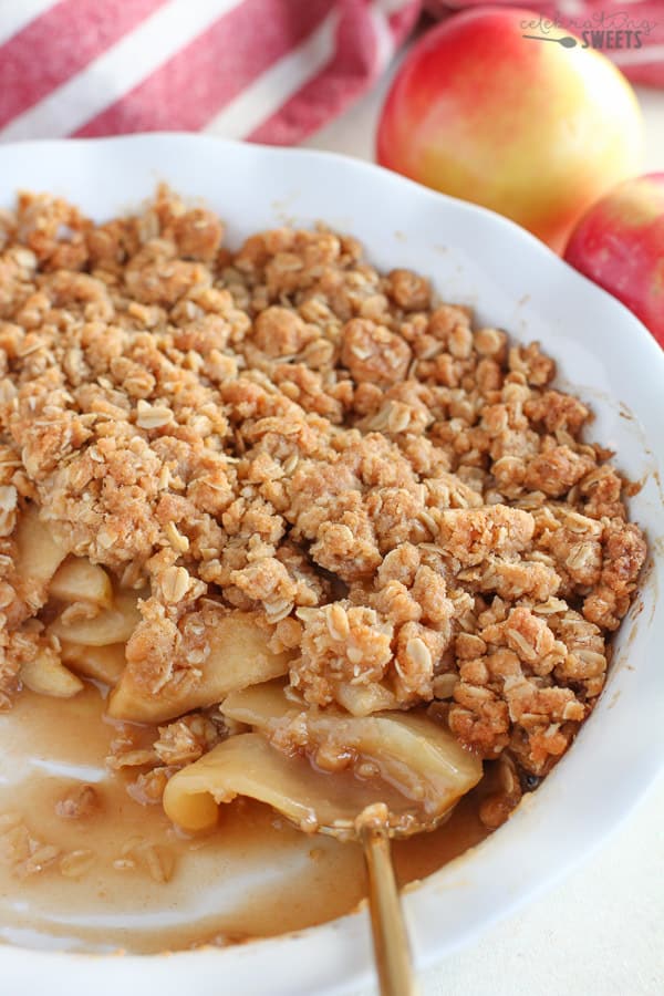 Apple Crisp in a white baking dish with apples in the background.
