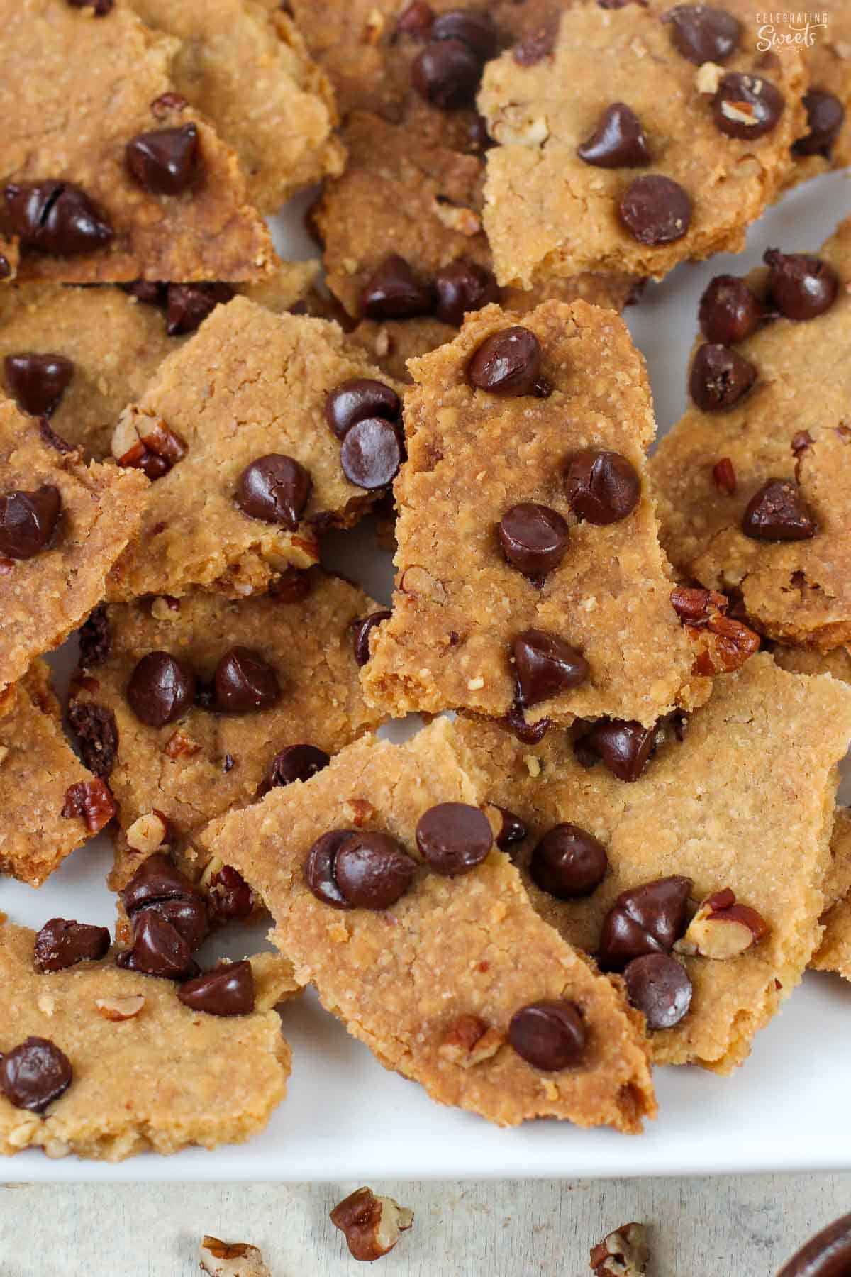 Chocolate chip cookie brittle pieces on a white plate.