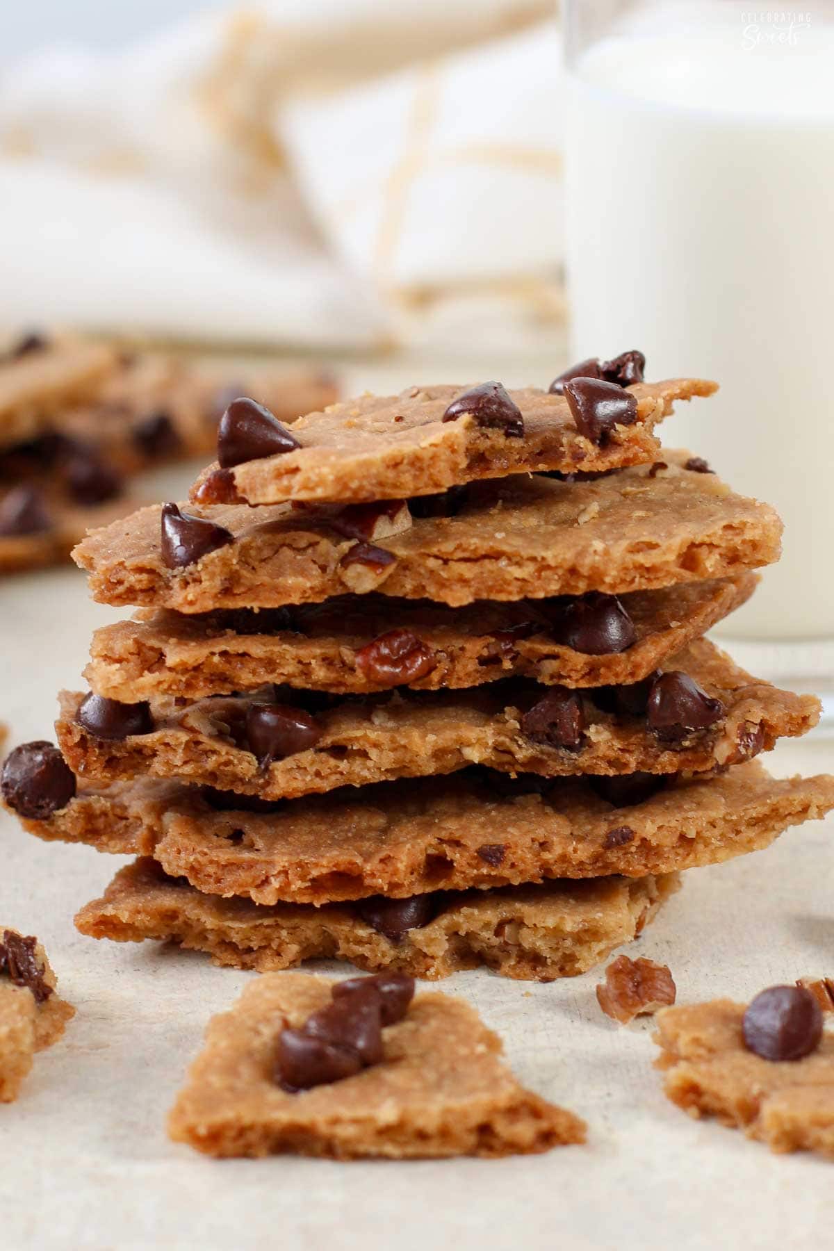 A stack of chocolate chip cookie brittle on parchment paper.