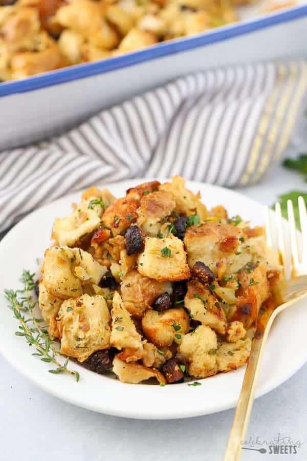 Fig and Sausage Stuffing on a white plate with a gold fork.