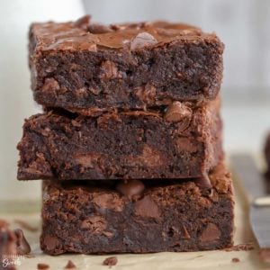 Stack of three brownies on parchment paper