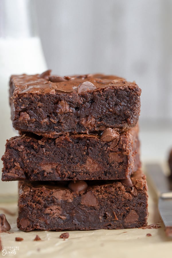 Stack of three brownies on parchment paper