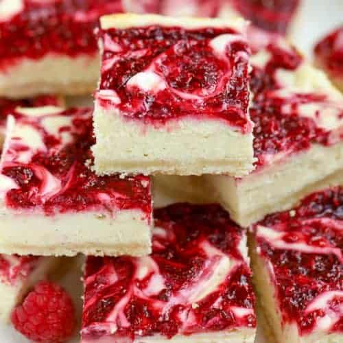 Pile of cheesecake bars swirled with raspberry puree.
