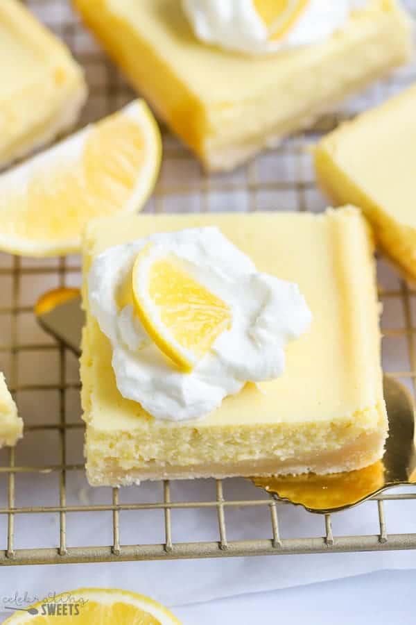 Lemon Bar topped with whipped cream on a spatula.