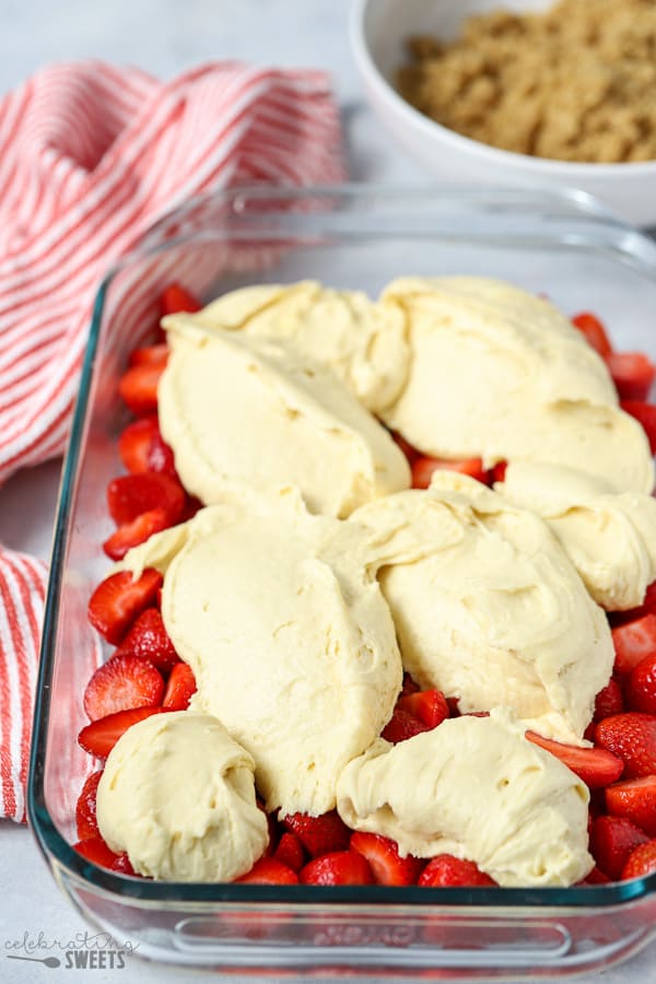 Strawberries in a baking dish topped with cake batter.