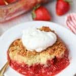 Strawberry Crumb Cake on a white plate with a dollop of whipped cream.