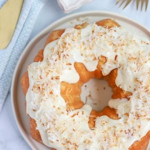 Coconut Bundt Cake topped with cream cheese frosting and toasted coconut.